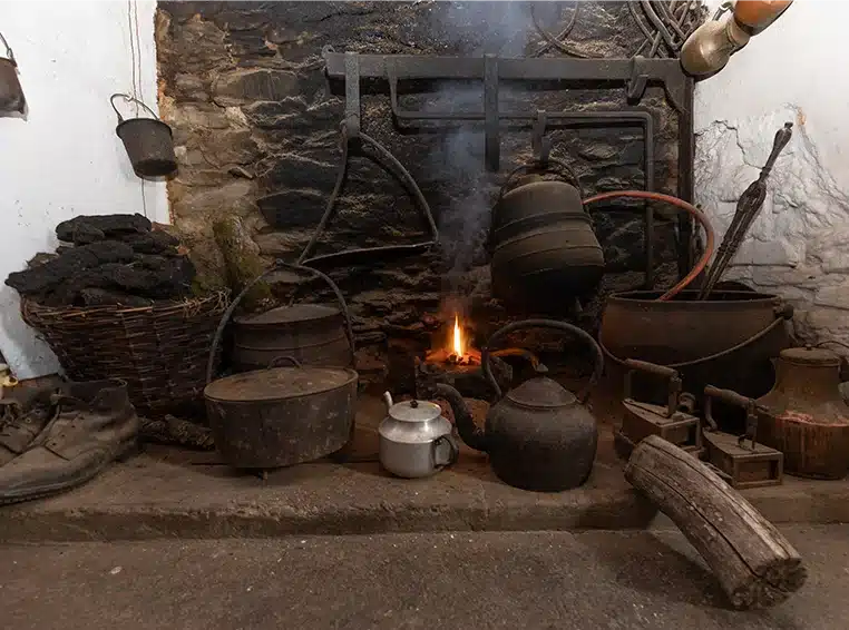 Small fire in fireplace with old kettles